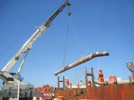 Grúa izando tubería durante una maniobra de carga